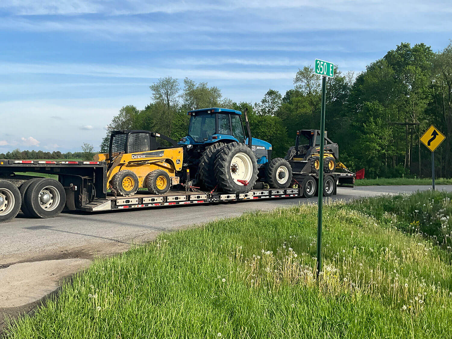 Skid Steers and Tractor on a Trailer 