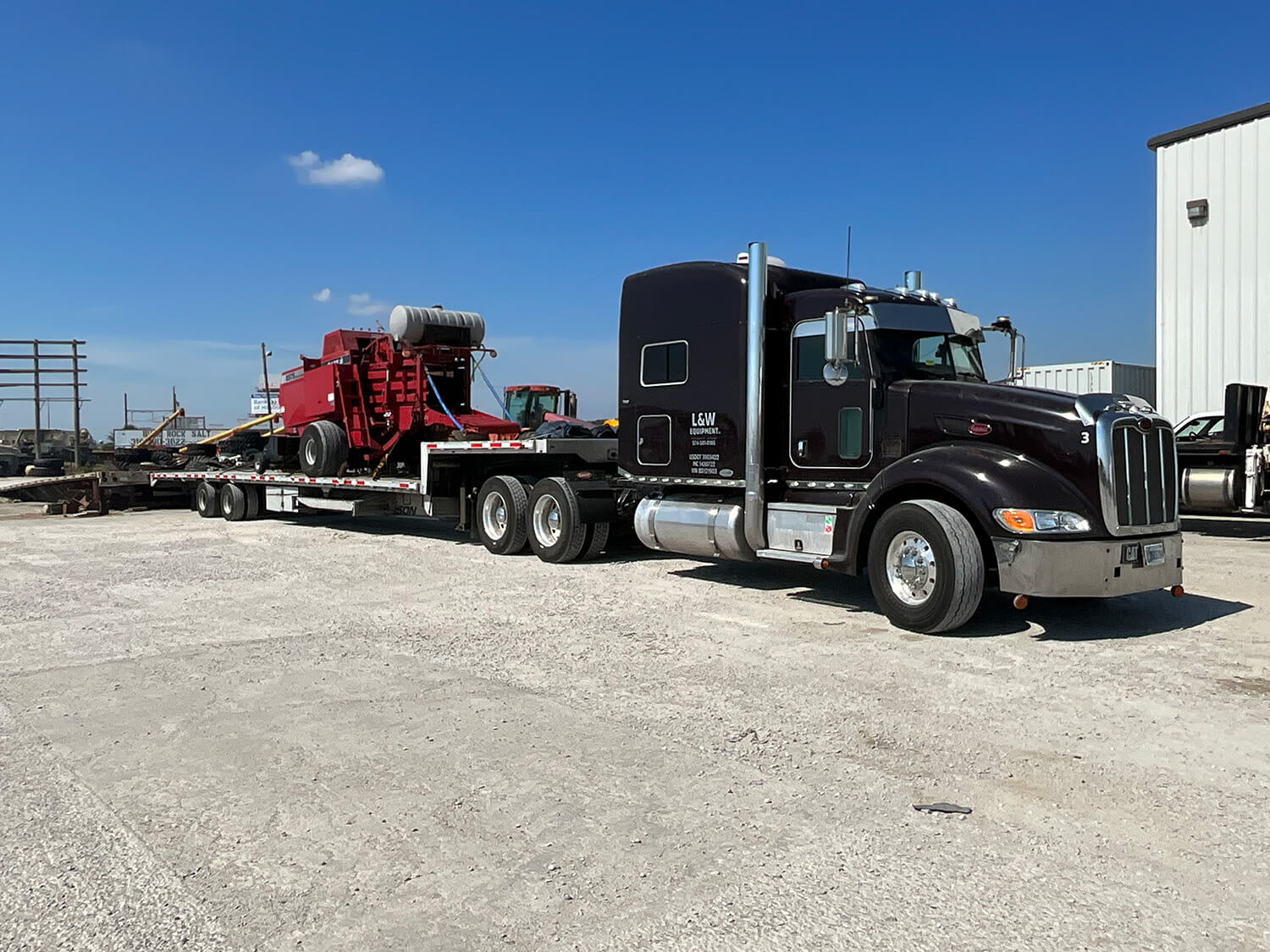 Black Semi hauling red baler